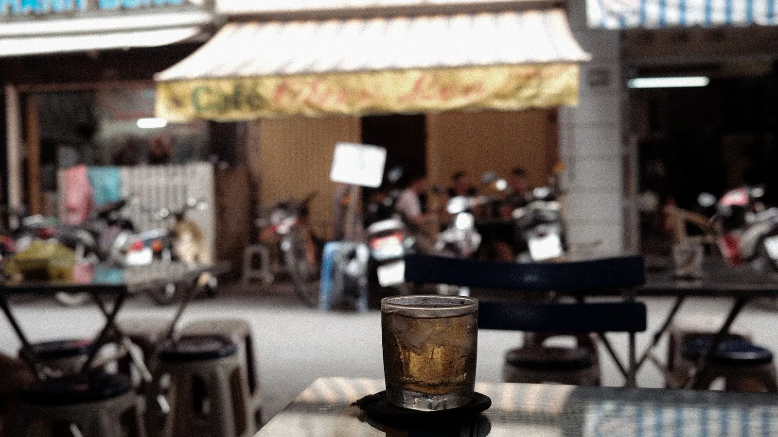 A glass of iced coffee on a table at a Saigon street cafe
