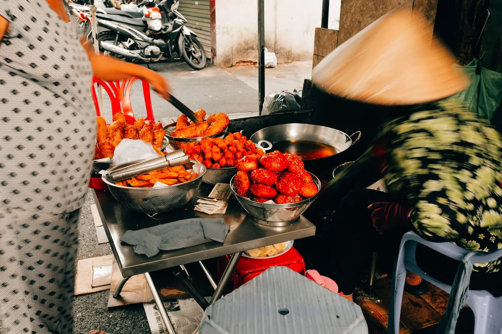 Fried chicken displayed in bowls at a street food stall