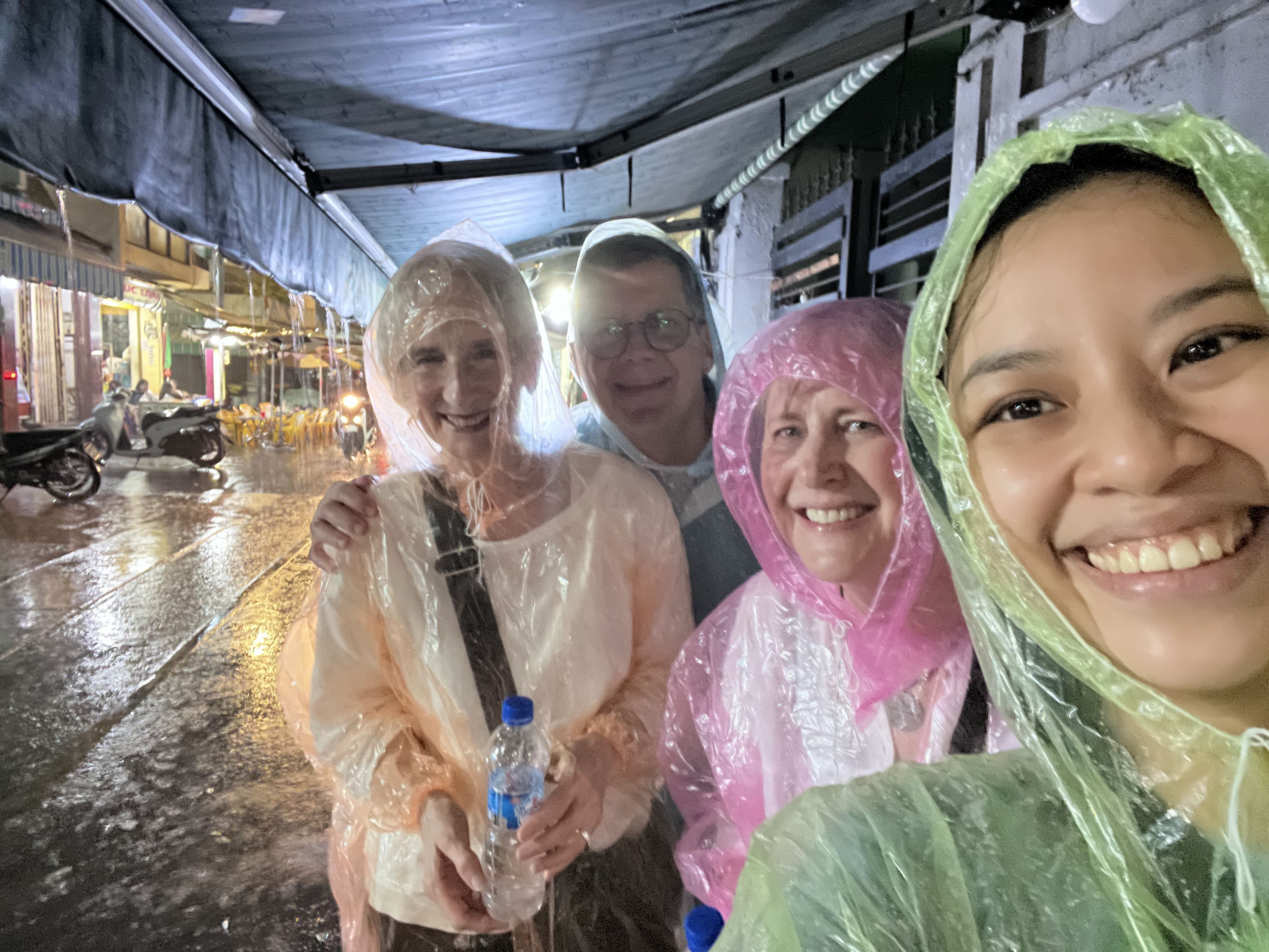 Spring and guests in colourful rain ponchos during a Saigon tour