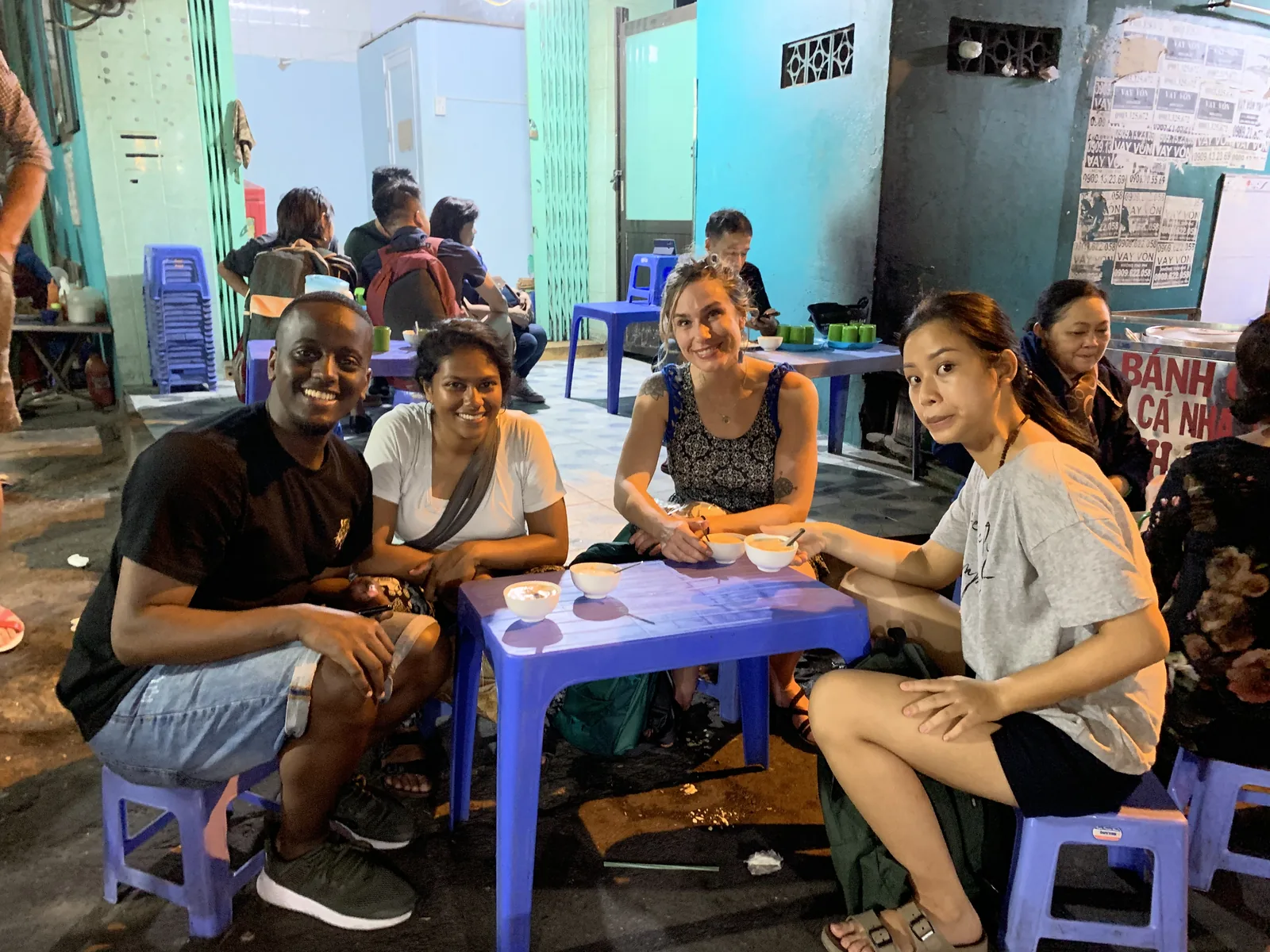 Spring sharing bowls of Vietnamese dessert with guests at a street food stall at night