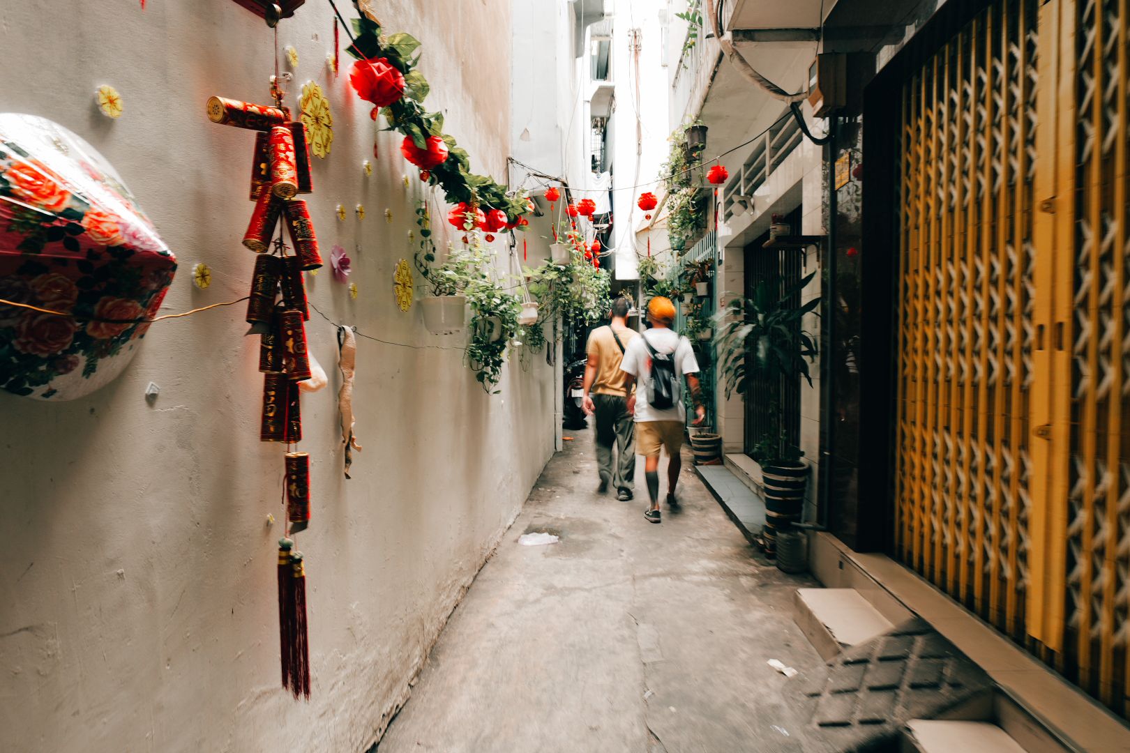 A narrow alley decorated with red lanterns and flowers in Saigon