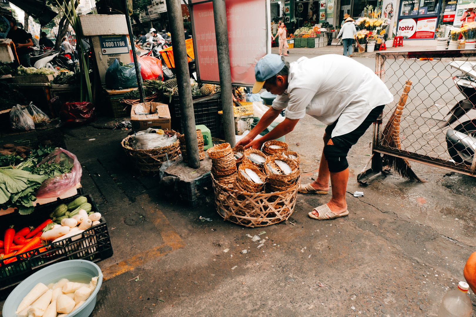 A market vendor arranging baskets outside a Saigon morning market