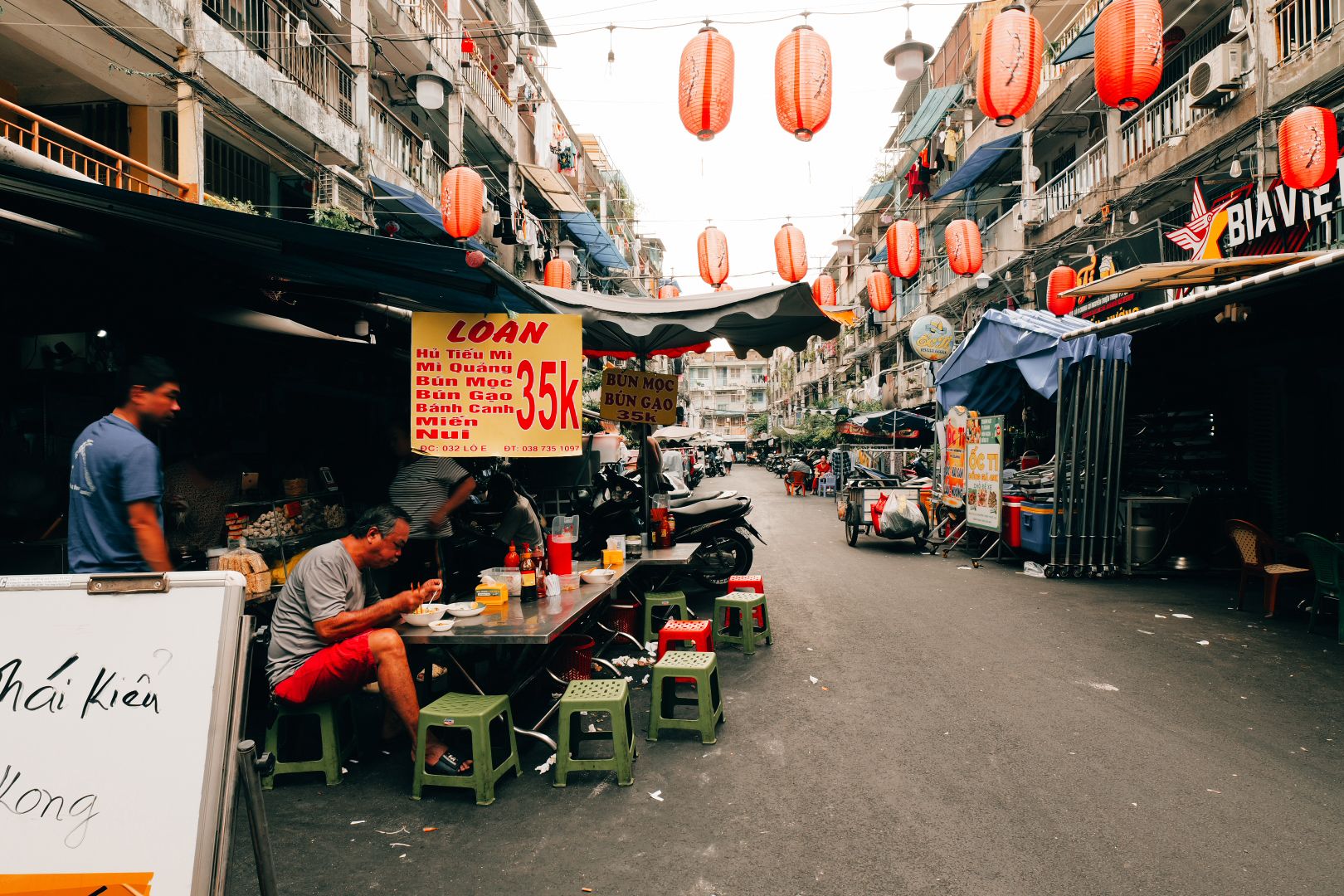 A street food stall with plastic stools and noodles in Saigon