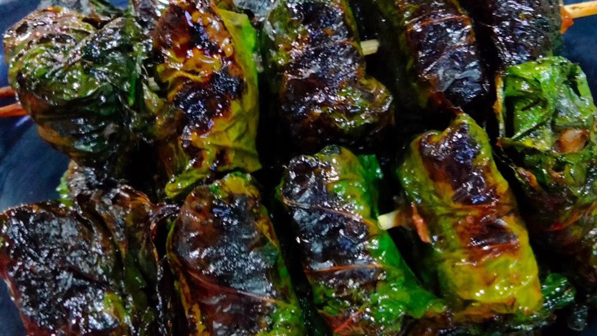 Vegan bo la lot, betel leaf wrapped filling on skewers, freshly grilled