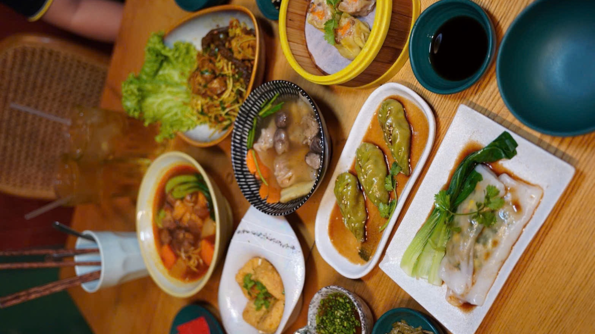 An overhead spread of multiple vegan Vietnamese dishes on a wooden table