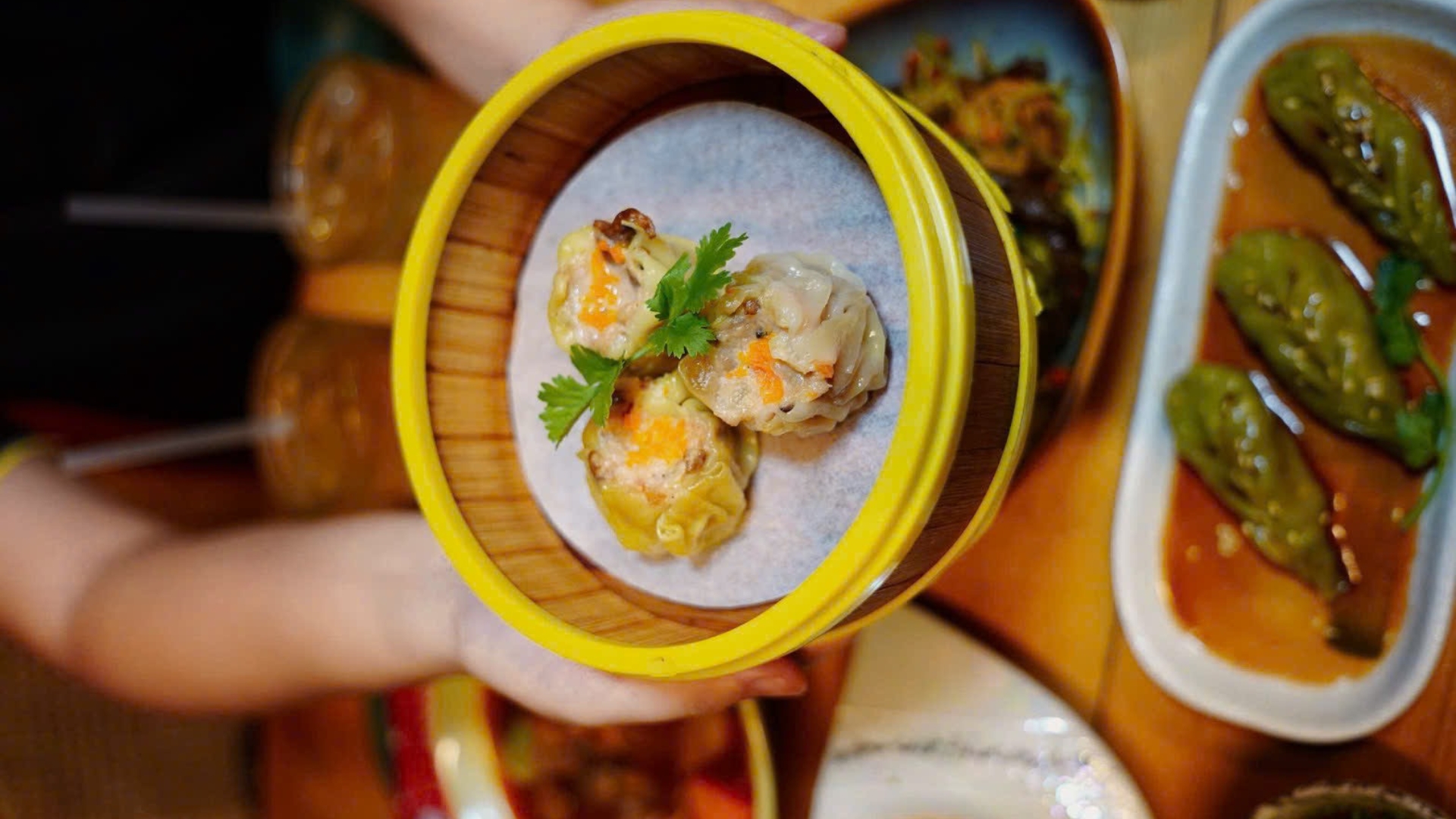 Vegan steamer dumplings in a yellow-rimmed bamboo basket